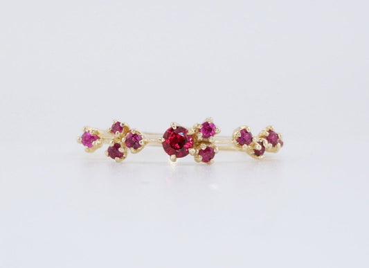 A cluster of rubies dancing on a thin gold ring band, the Lumi Ring from Vazana.